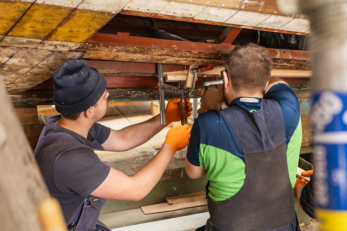 Mitarbeiter bei Arbeiten in der Werfthalle 
